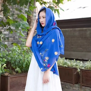 Elegant blue floral embroidered shawl and lightweight beach scarf for women in a garden setting