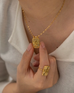 Detail shot of gold snake pendant necklace and matching ring set with zircon on a model