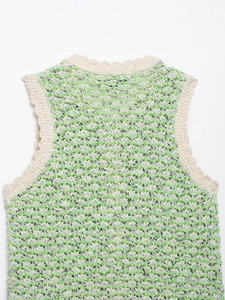 Close-up of textured hollow knit vest with green and beige stripes and ribbed neckline