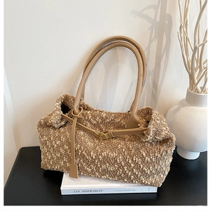 Detail view of brown plush tote bag texture with tan leather straps and tie detail