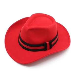 Detail of red wool felt cowboy hat featuring a black and red striped decorative band