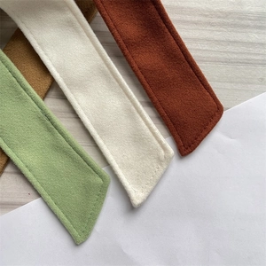 Detail view of multicolored wool fabric belts with premium stitching and suede texture