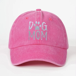 Detailed texture of pink washed cotton baseball cap with gray DOG MOM print and paw icon