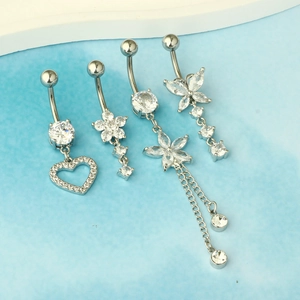 Detail of four silver belly rings with zircon hearts and tassels on a light blue base