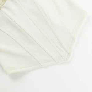 Detail of white corset top showing reinforced boning structure and vertical stitching