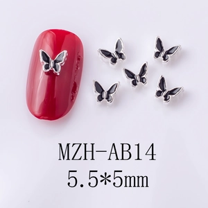 Macro view of 5.5x5mm black oil butterfly nail art charms on red glossy nails