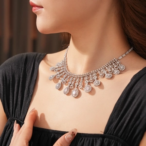 Close-up of a silver zircon flower teardrop pendant necklace worn by a model