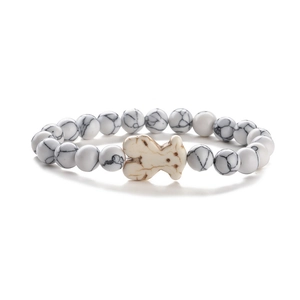 Bracciale elastico con perline in marmo bianco e un ciondolo centrale a forma di orso crema