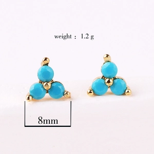 Detailed view of 8mm gold-plated stud earrings with three blue cubic zirconia stones