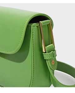 Detail showing bright green leather material and golden square metal buckle on a shoulder bag