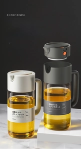Detail view of gravity flip lid on 550ml glass oil bottle with auto open and close function