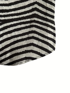 Macro detail of black and white striped shirt hem with professional stitching and curved cut