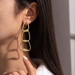 Irregular 18K gold geometric earrings with sparkling rhinestones worn by a model