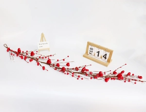 Close-up of flexible Valentine heart berry vine with red hearts and white beads decor
