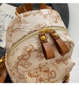 Gros plan sur la fermeture éclair fluide et la texture grainée du sac à dos beige chic