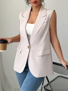 Detail of light pink sleeveless blazer vest featuring lapels and single-breasted buttons