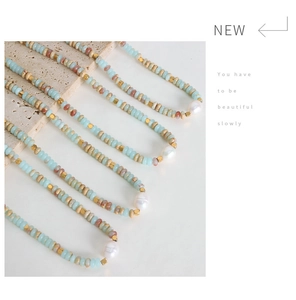 Detail of beaded necklaces with blue and beige beads and irregular baroque pearls