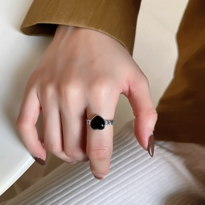 Detail of 925 silver ring featuring a black heart agate and braided texture on the band