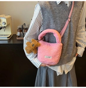 Pink plush faux fur bucket bag with a cute teddy bear charm and adjustable shoulder strap