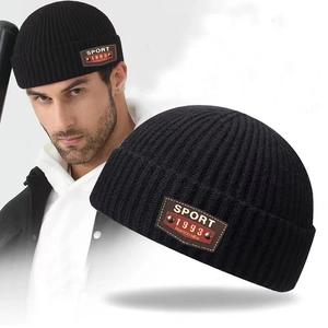 Classic black ribbed knit beanie with brown leather sport patch for winter warmth