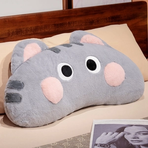 Close-up of soft grey plush cat pillow texture and cute pink ear details in bedroom