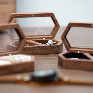 Macro detail of walnut wood hexagonal jewelry box with glass lid and velvet lining