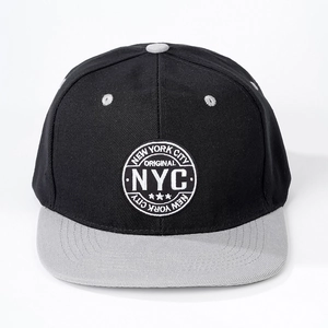 Détail de l'écusson brodé NYC sur une casquette bicolore noir et gris à bord plat