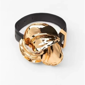 Modieuze armband met gouden metalen bloem en zwarte lederen band in moderne stijl