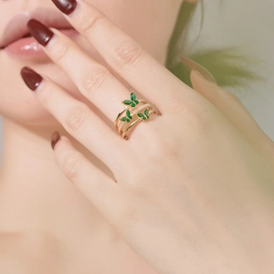 Detail of s925 silver wrap ring with green zircon butterflies on model finger