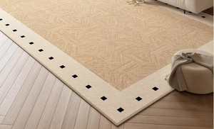 Close-up of woven sisal rug texture with elegant black checkered border on wood floor