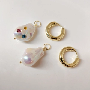 Baroque pearl earrings with gold hoops and colorful rhinestone accents on white background