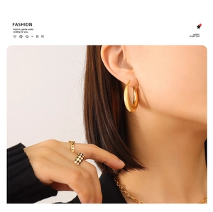 Dettaglio di orecchini a cerchio a U placcati in oro 18K su una modella in stile minimal