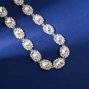 Close-up of sparkling oval-shaped crystals set in silver links on a dark textured background