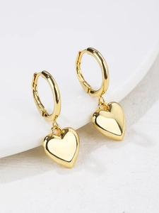 Detail of gold 3D heart hoop earrings with polished mirror finish on white background