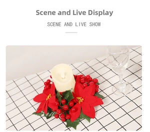 Close-up of red poinsettia and berry wreath with ivory pillar candle on plaid cloth