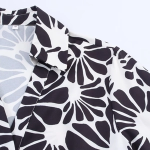 Detail shot of the halter neckline and black and white floral print on a summer maxi dress