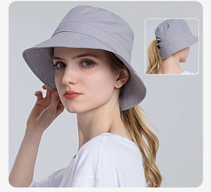 Detail of grey sun hat with ponytail hole and adjustable toggle for outdoor sun protection