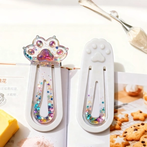 DIY cat paw resin molds for bookmarks featuring star sequins and glitter in creative setup
