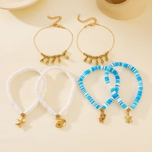 Detalle de set de joyas playeras con colgantes de estrella de mar y tortuga en tobilleras