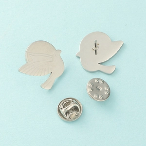 Broche colombe de la paix en acier inoxydable poli argenté avec fermoir papillon sur bleu