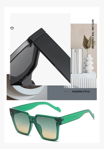 Detail view of reinforced hinges and oversized green frames on trendy sunglasses