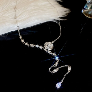 Detailed close-up of a silver Y-necklace featuring a crystal flower and drop pendant