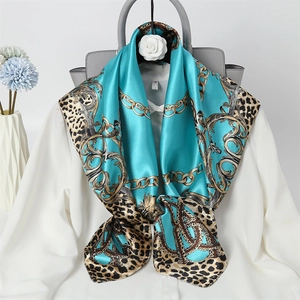 Blue silk scarf with gold chains and leopard print draped over a white shirt