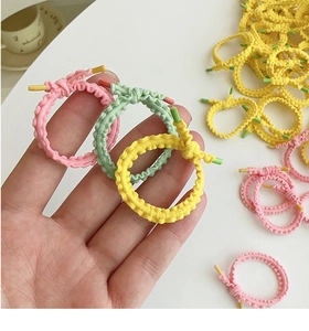 Close-up of colorful braided elastic hair ties with scalloped texture and plastic tips