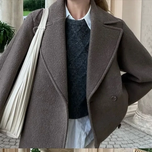 Detail of dark brown wool coat with double-breasted design and layered autumn outfit