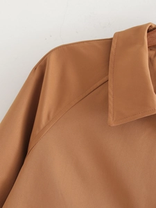 Detail of the camel open-front coat collar and raglan sleeve stitching quality