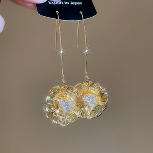 Détail de boucle d'oreille fleur plaquée or 18K avec zircon et crochet long