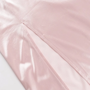 Detail of pink satin evening gown showing the side slit and smooth fabric texture