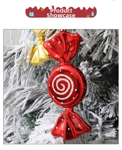Close-up of red and gold candy-shaped Christmas tree ornaments with white spiral patterns