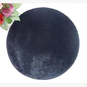Detailed view of the soft black round plush rug with a thick shaggy pile texture